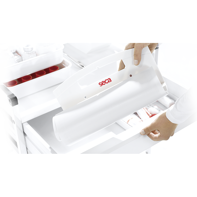 White seca 210 measuring mat for infants held up over the top of a white trolley with a white background.