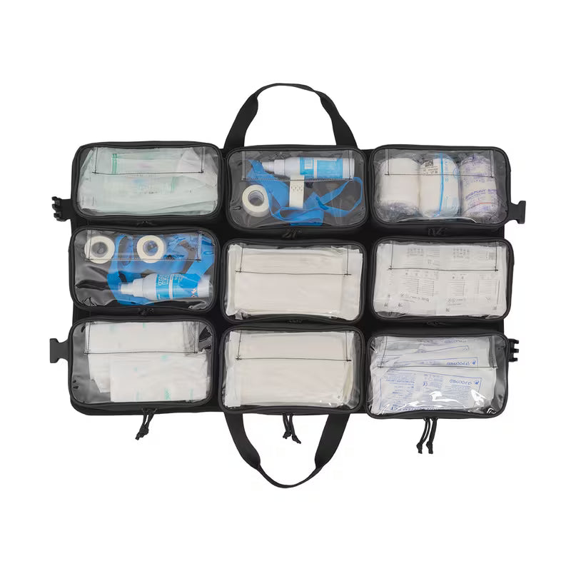 An open black Elite Bags TRIA modular panel with nine clear front pockets containing various medical supplies such as bandages, gauze, tape, and a blue tourniquet, shown on a white background.