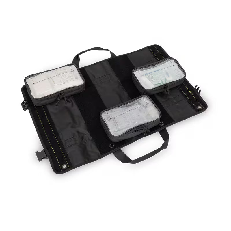A black Elite Bags TRIA modular panel, shown open to reveal four zippered pockets with clear plastic lids containing white and green medical supplies, set against a plain white background.